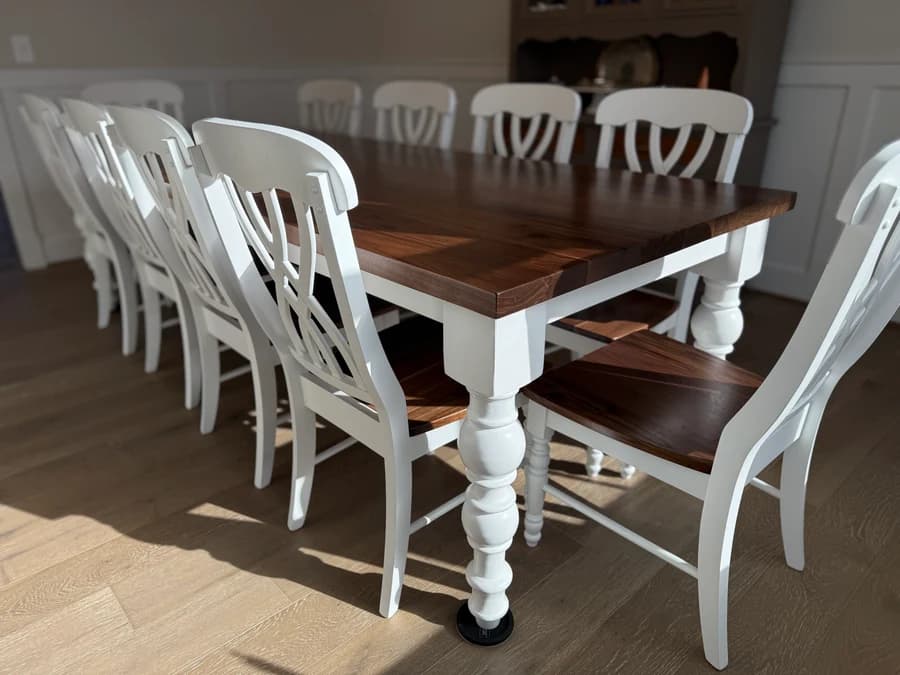 Handcrafted solid wood farmhouse dining table with a stained wood top and chunky turned legs.